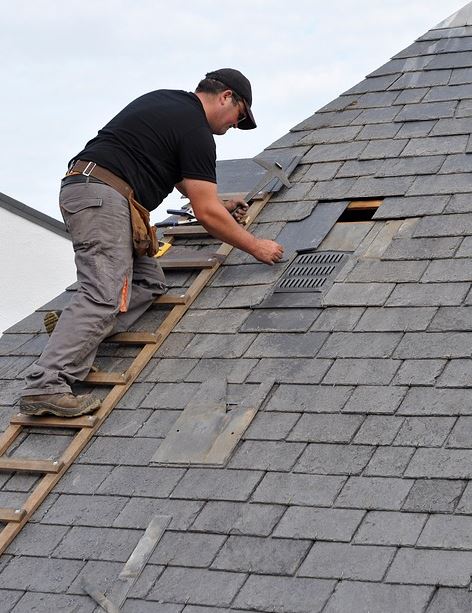 un couvreur qui pose des tuiles sur un toît